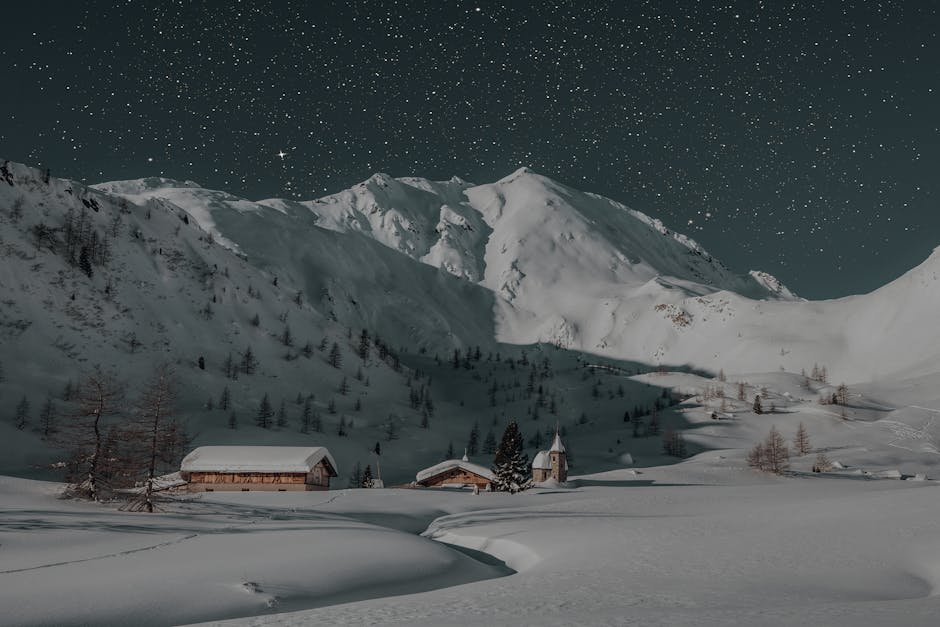 A serene winter night scene featuring a snow-covered mountain resort under a starry sky, ideal for travel and nature enthusiasts.