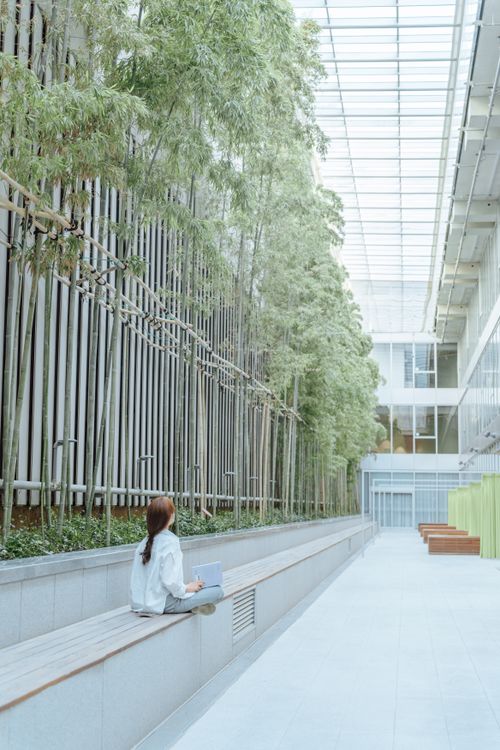 Girl Sitting in Modern Architecture Patio · Free Stock Photo