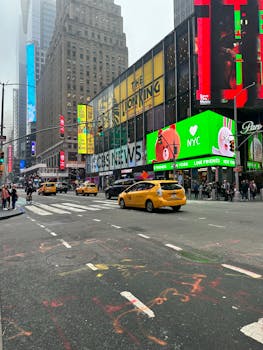 Vibrant street scene in Times Square, NYC, showcasing iconic billboards and yellow taxis.
