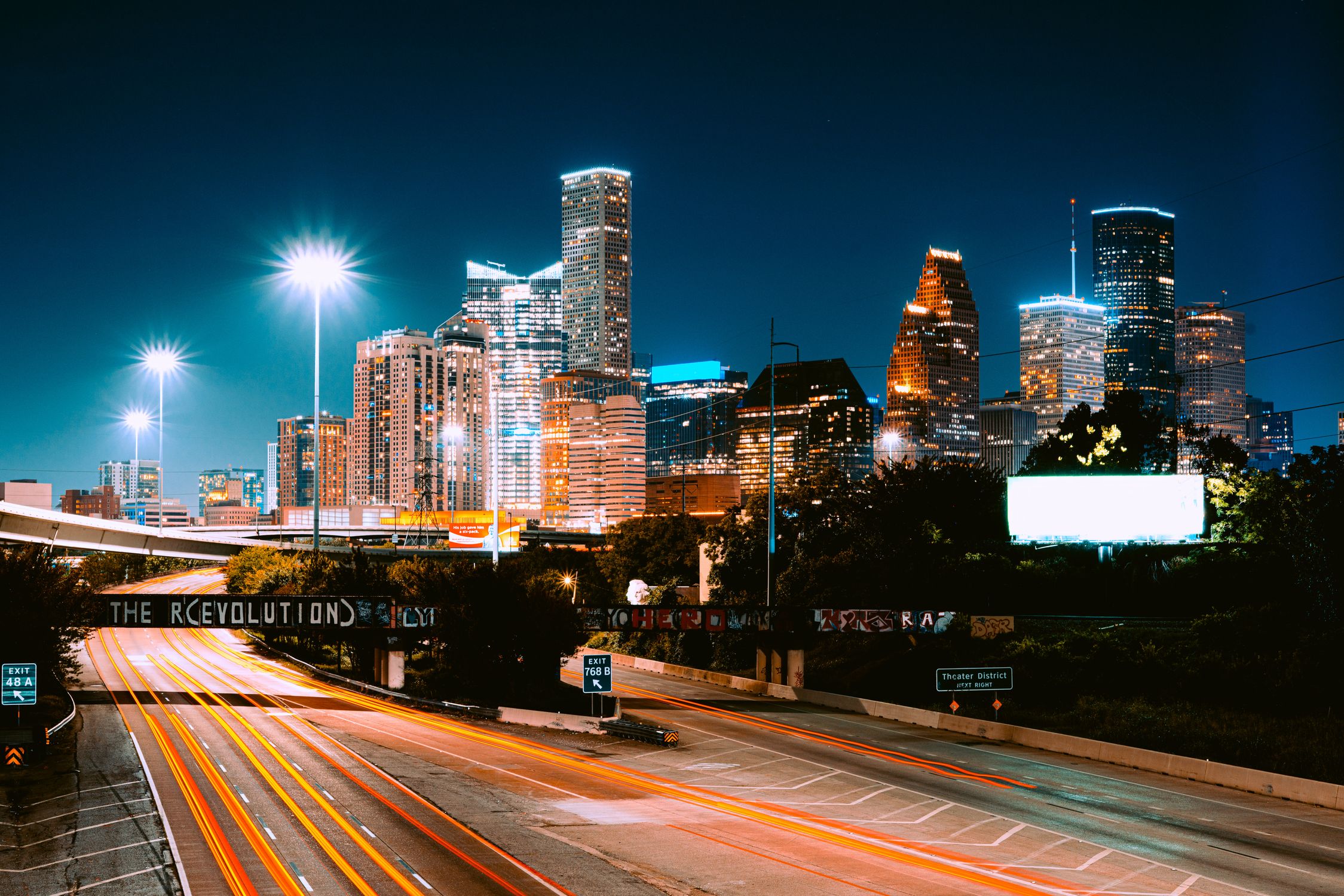 Captivating view of Houston's skyline at night with light trails and illuminated buildings.