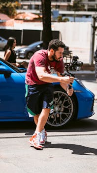 A filmmaker concentrating with a camera stabilizer outdoors, capturing dynamic city scenes.