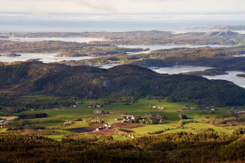 Greenfield Et Fermes Sur La Côte Norvégienne Avec Un Parc éolien Au Loin