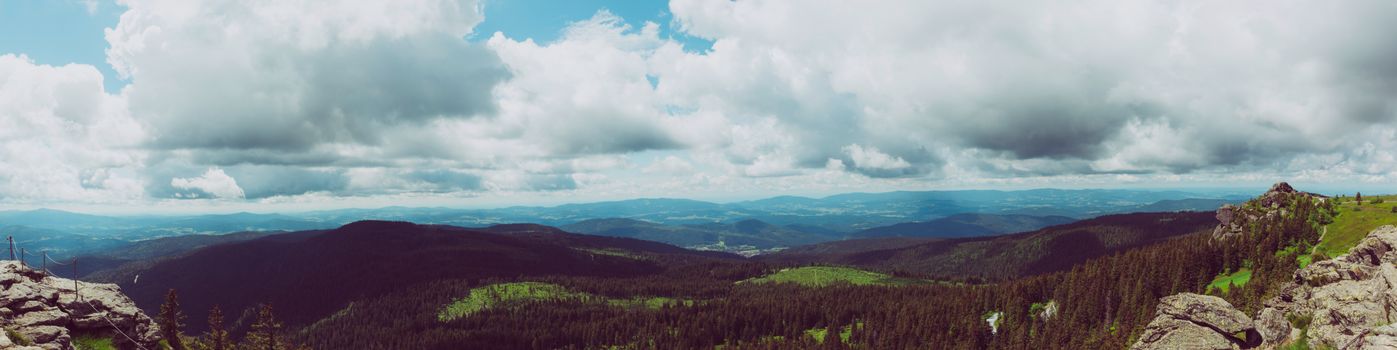 A stunning panoramic view of a mountain range under a dramatic cloudy sky.