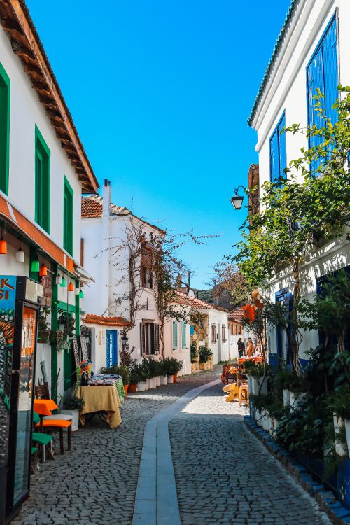 Free Explore the charming narrow street in Sığacık, İzmir, showcasing traditional Turkish architecture. Stock Photo
