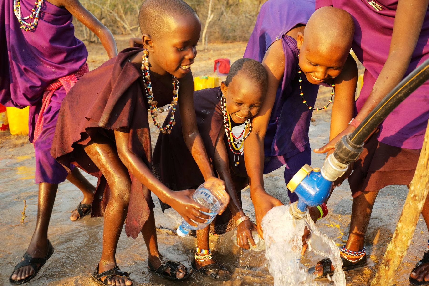 Children gathering around a communal clean-water tap in Tanzania