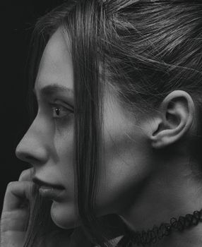 Artistic black and white side profile portrait of woman wearing a choker.
