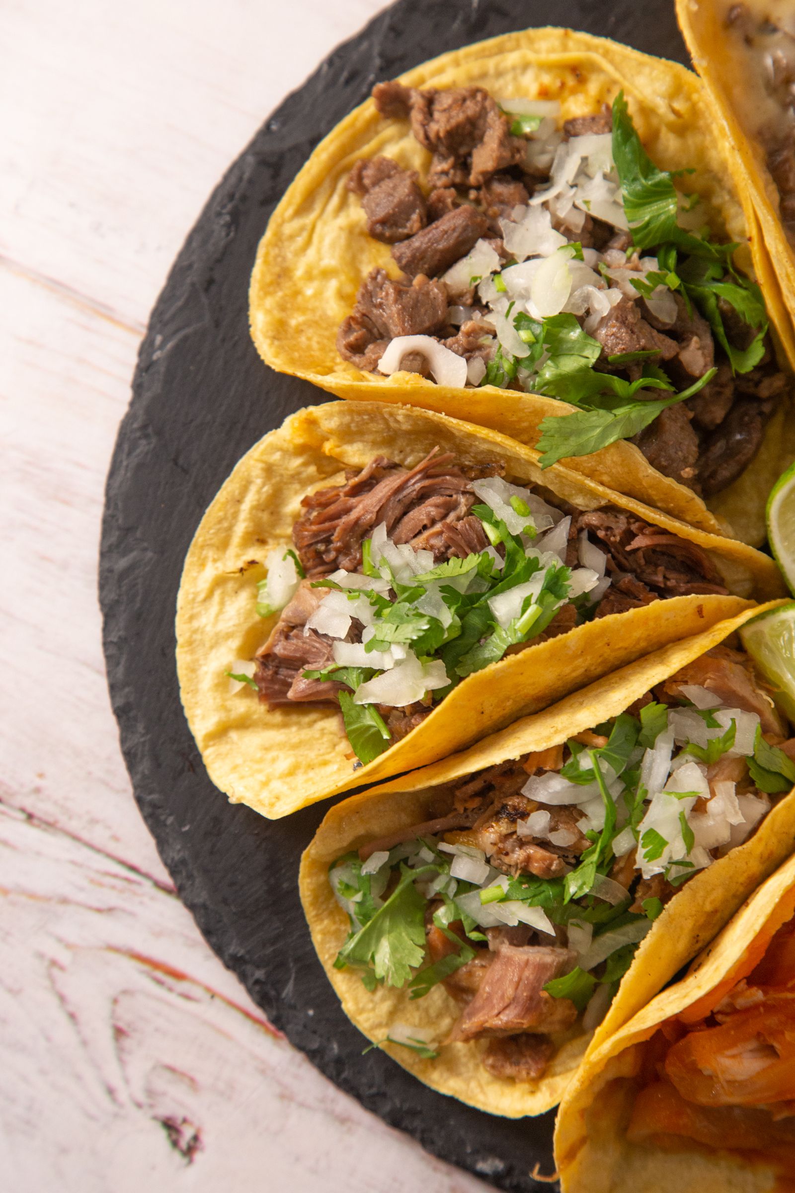 Close-up of beef tacos with onion and cilantro on corn tortillas