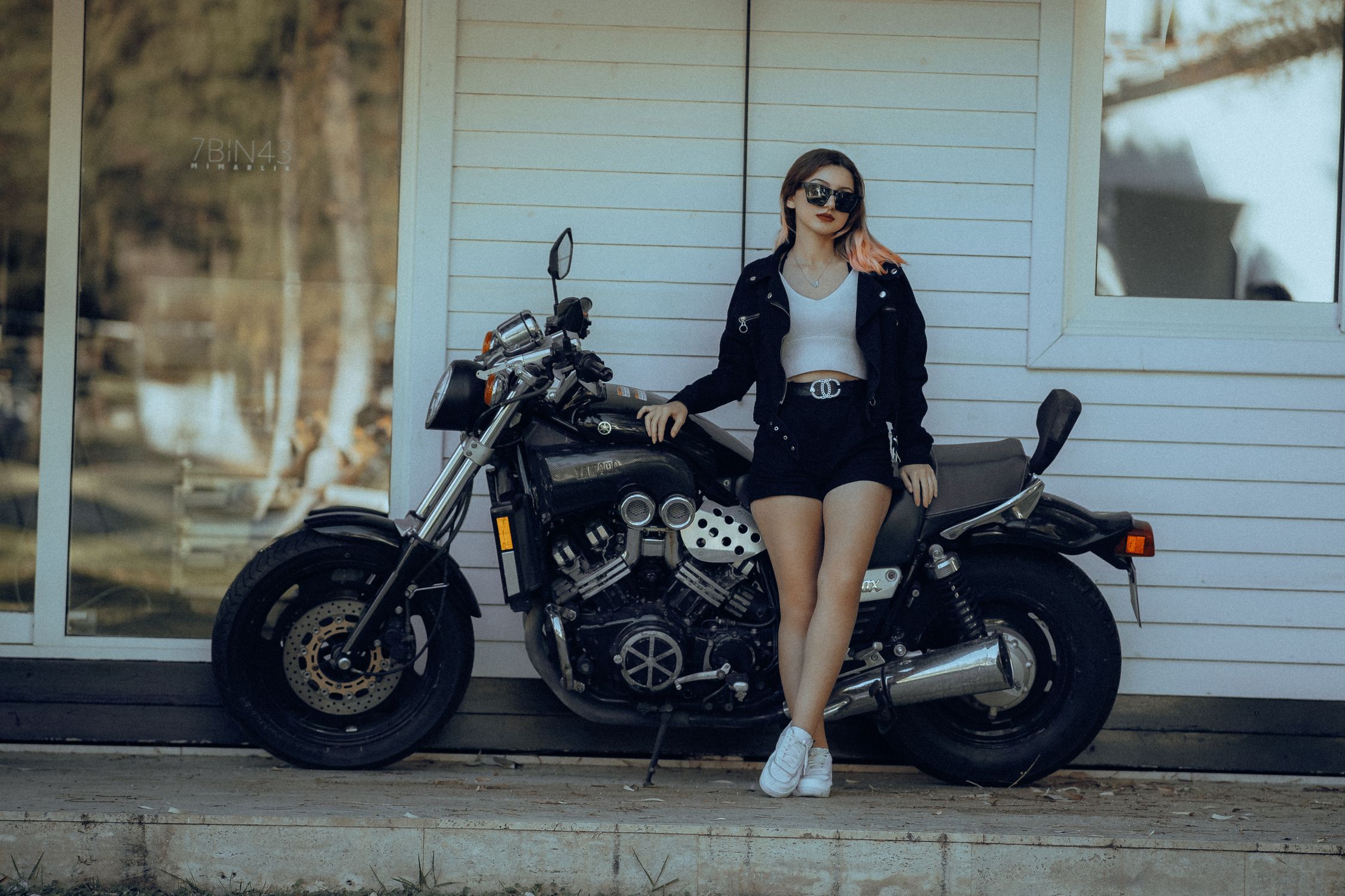 A Woman in Black Jacket and Shorts Standing Near the Big Bike Parked on ...
