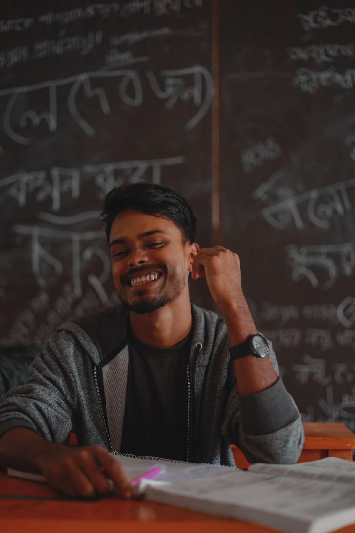 A teacher beside a chalkboard.