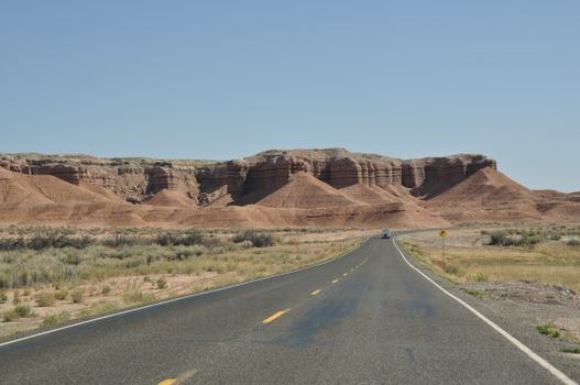 Explore the scenic views of a deserted road through Hanksville's stunning rock formations in Utah.