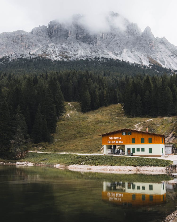 House Reflection In Water In Mountain Landscape