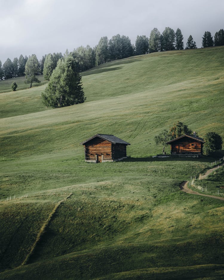 Wooden Cabins On Hill In Mountain Landscape