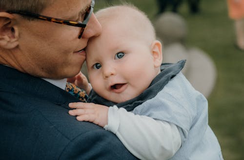 Free Close Up Photo of Man Carrying a Baby Stock Photo