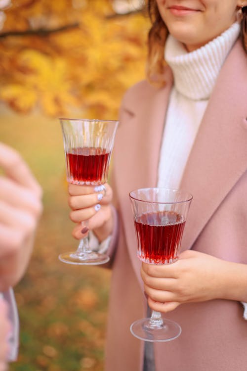 A Woman holding Two Wine Glasses