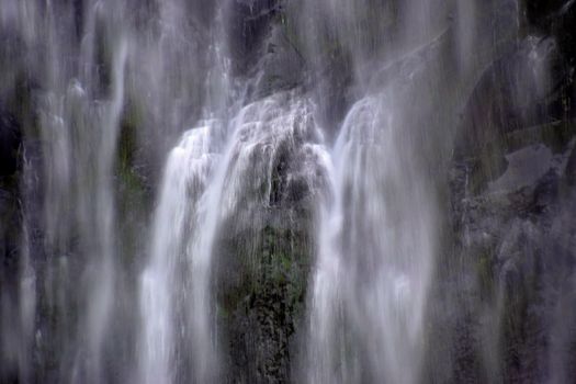 A tranquil long exposure shot of a cascading waterfall, creating a smooth flowing water effect.