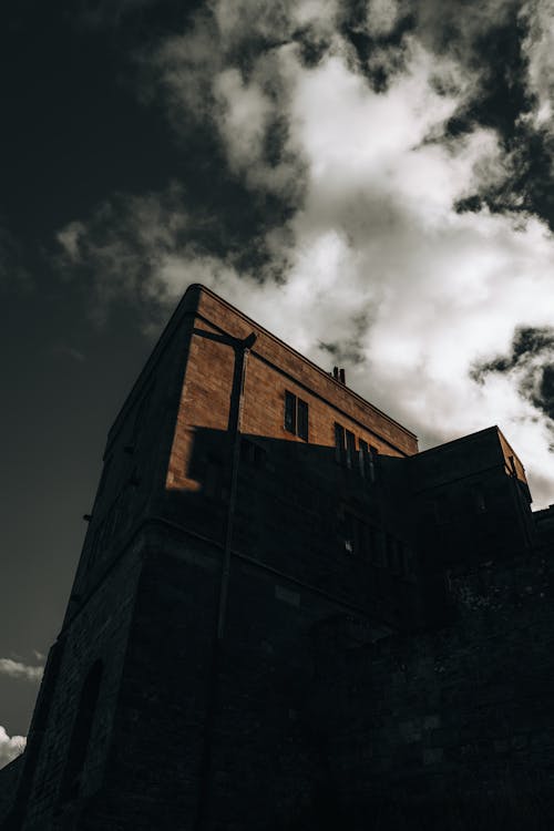 A Low Angle Shot of a Concrete Building Under the Cloudy Sky