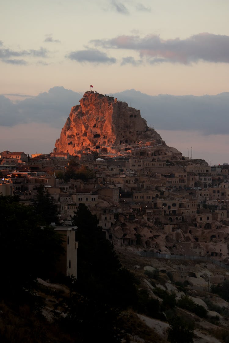 City On Hill Near Mountain In Sunset