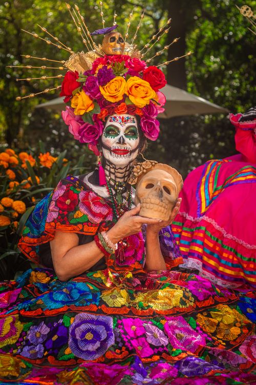 Free A woman in colorful Day of the Dead costume with skull makeup and floral headdress. Captured in Mexico City. Stock Photo