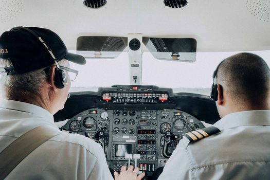 Photo by Amar Preciado Close-up view of two pilots managing the cockpit controls of an aircraft, focusing on instrumentation.
