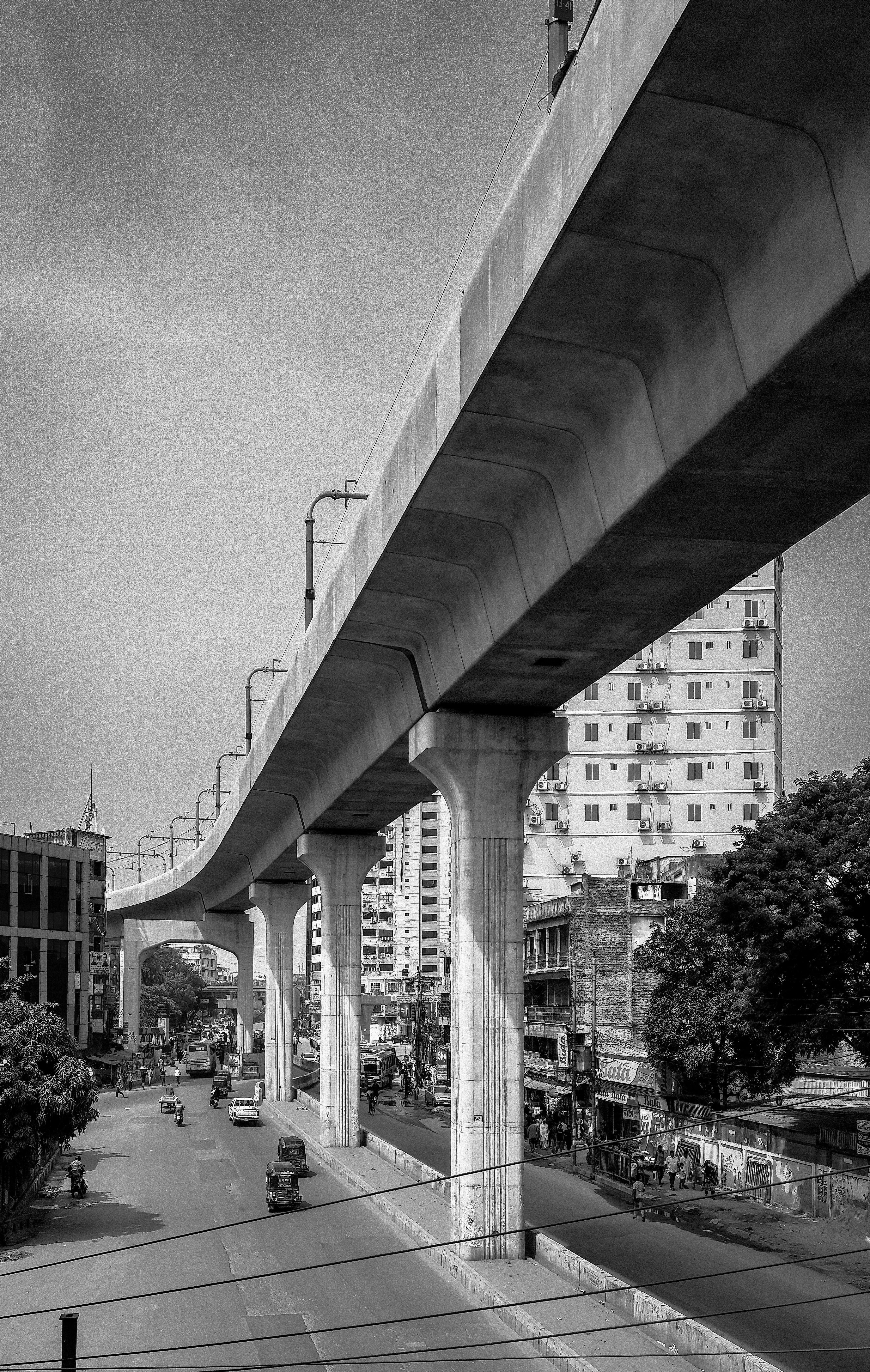 Black and white view of Dhaka's elevated highway, highlighting urban architecture and city streets.