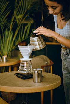 A woman preparing pour-over coffee in a cozy café setting in Eskişehir, Türkiye.