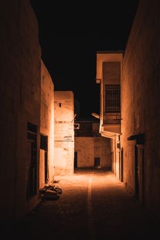 Captivating night alley in Şanlıurfa with dramatic lighting and historic architecture.