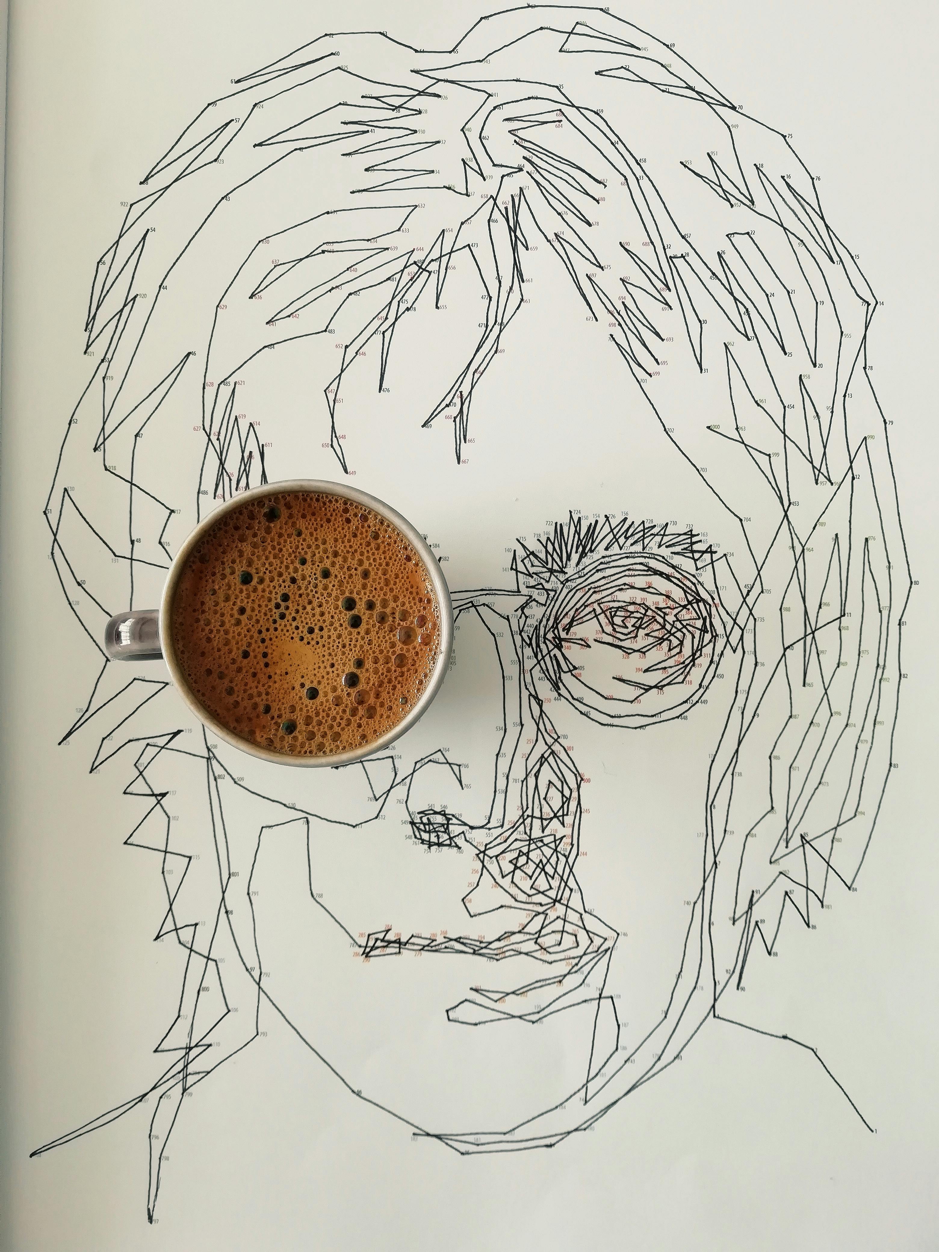 Ceramic coffee cup placed on a line art sketch, adding depth to the portrait.
