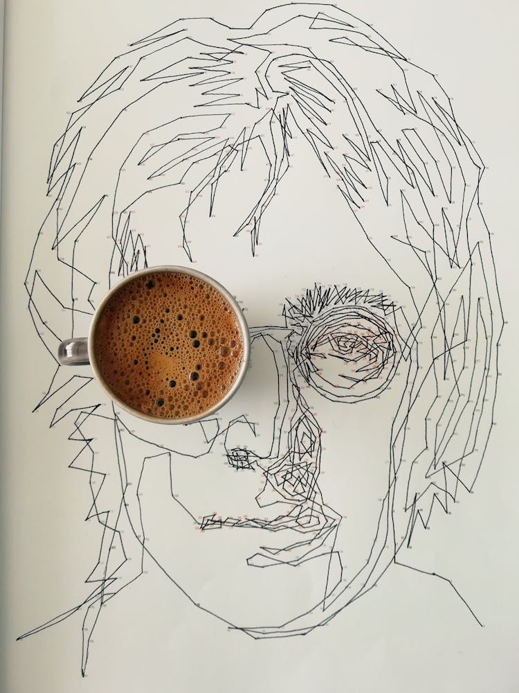 A Cup Of Coffee On White Paper With Sketch