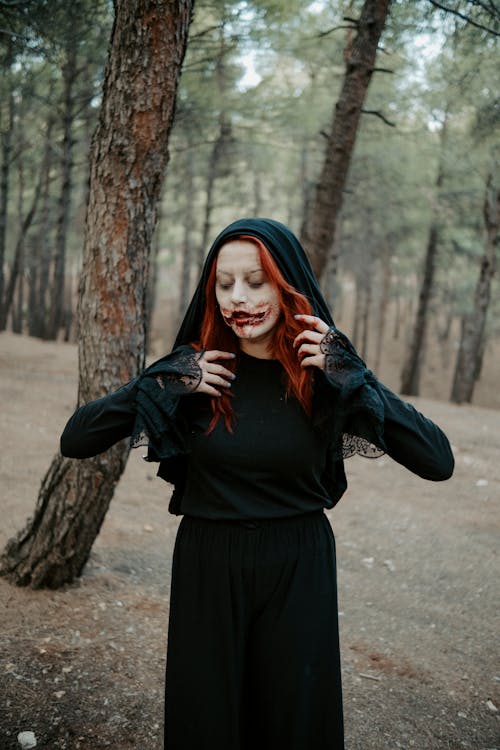 Woman in a Halloween Costume and Makeup in a Forest 