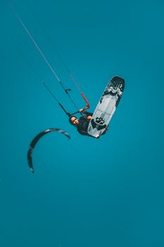 Woman performing an aerial kiteboarding trick, showcasing skill and agility.