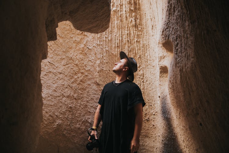 Man Standing In The Cave With A Camera In His Hand