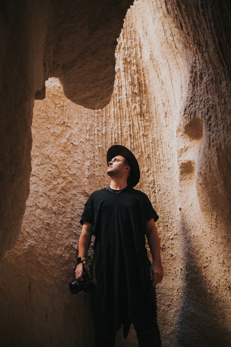 Man Standing In The Cave With A Camera In His Hand