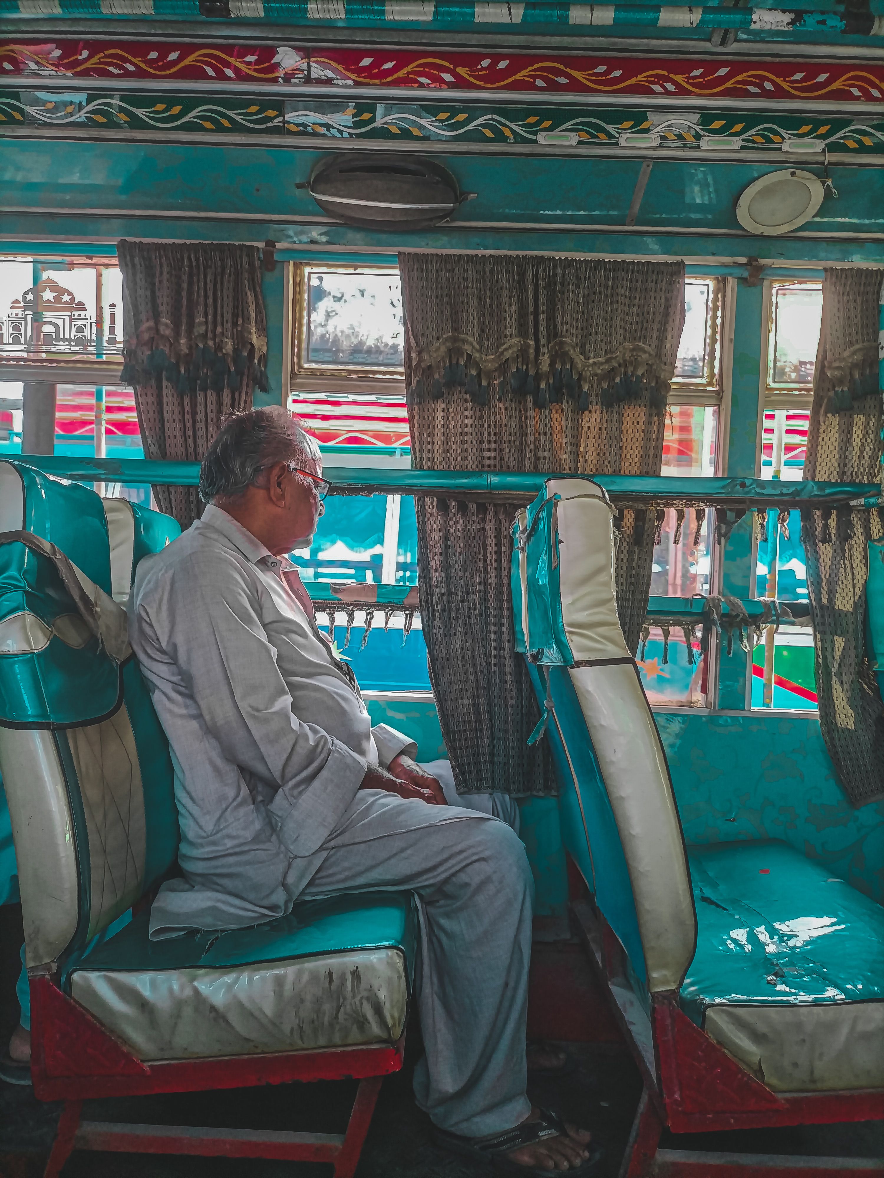 Man in Gray Long Sleeves and Pants Sitting Inside a Bus · Free Stock Photo