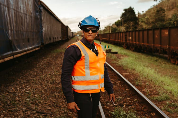 A Railroad Worker Posing On The Train Tracks 