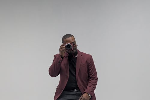 Man Wearing Suit Jacket Taking Photo with a Camera