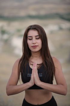 A young woman meditating with closed eyes in Mustafapaşa, Türkiye.