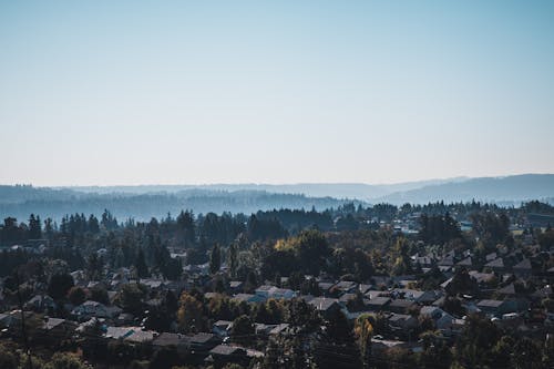 Aerial View of a Town Surrounded by Forest-covered Hills