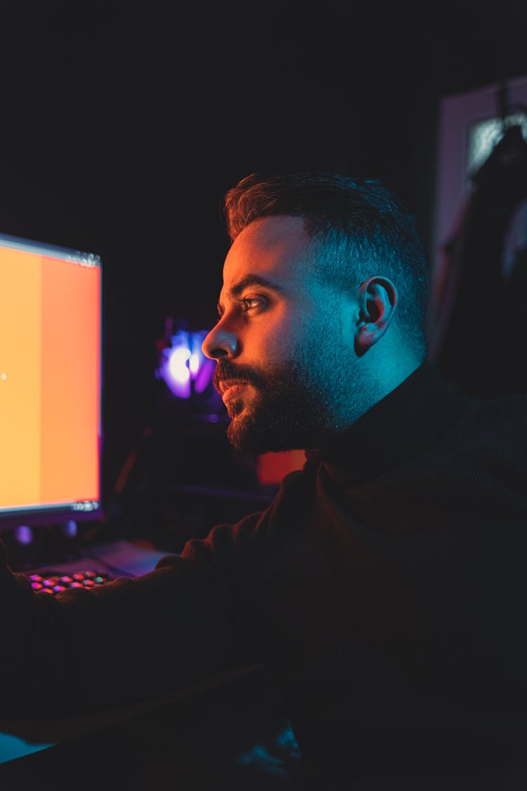 Man Working At A Computer In A Dark Room