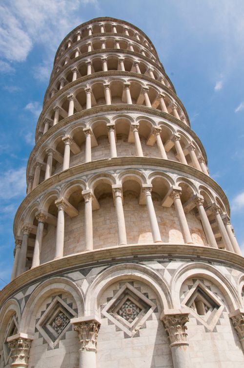 Free A low-angle view capturing the iconic Leaning Tower of Pisa under a clear blue sky in Italy. Stock Photo