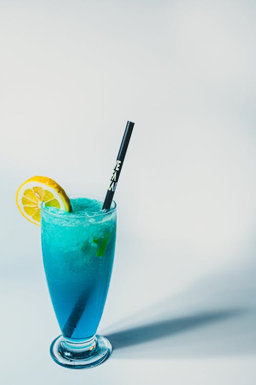 A Blue Cocktail with a Lemon Slice in a Tall Glass 