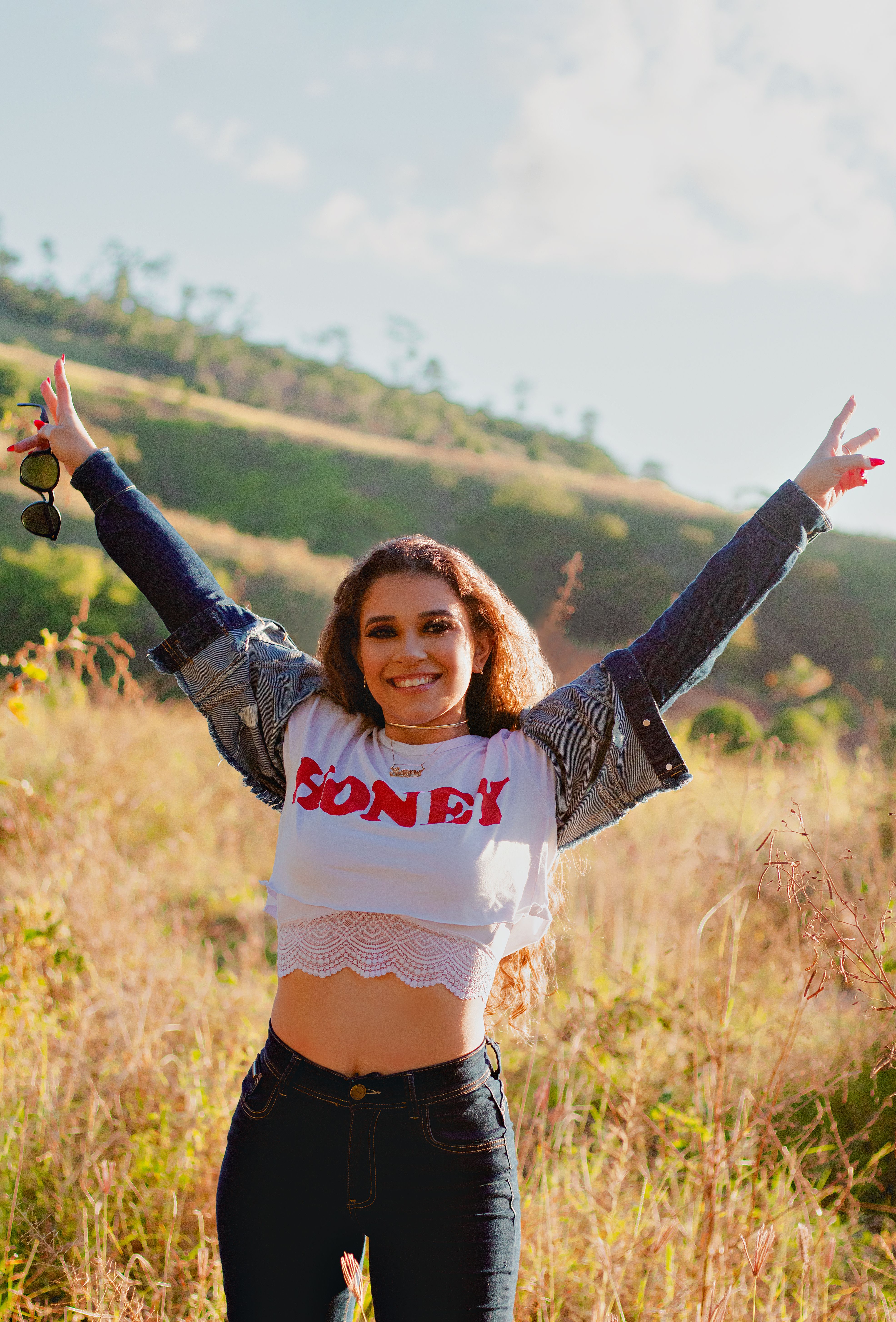 Woman in Crop Top and Denim Jacket Standing on Grass Field · Free Stock ...