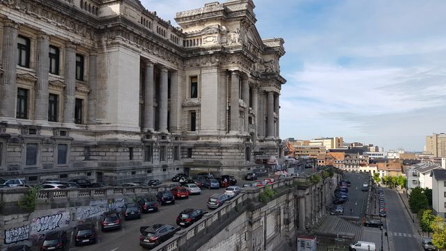 View of Brussels' iconic Palais de Justice with parked cars and urban landscape. — lounges at Brussels South Charleroi Airport