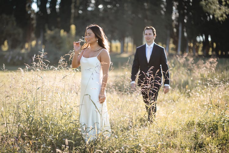 Couple Walking On Grass Fields