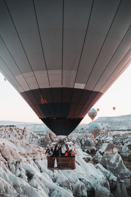 Free A breathtaking view of hot air balloons over Cappadocia's rocky terrain at dawn. Stock Photo