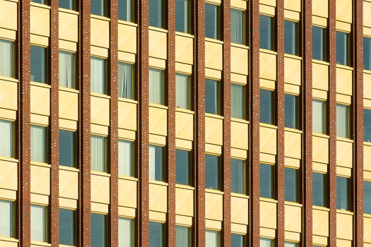 Abstract view of a geometric facade on a high-rise building with symmetrical windows.