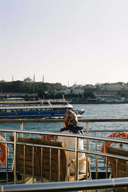 Free A Woman Enjoying the View of Istanbul Skyline  from a Boat Ride Stock Photo