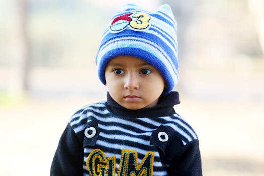 Adorable child wearing a striped outfit and beanie on a cool day.