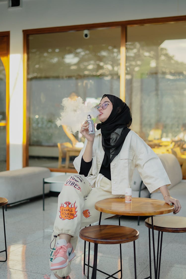 A Woman In Black Scarf Smoking Vape