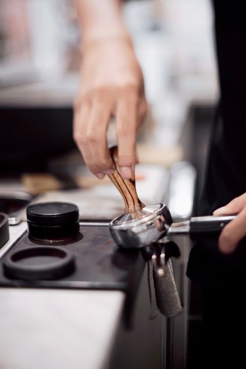 Free Close-up of a barista using a portafilter to prepare coffee in a café setting. Stock Photo