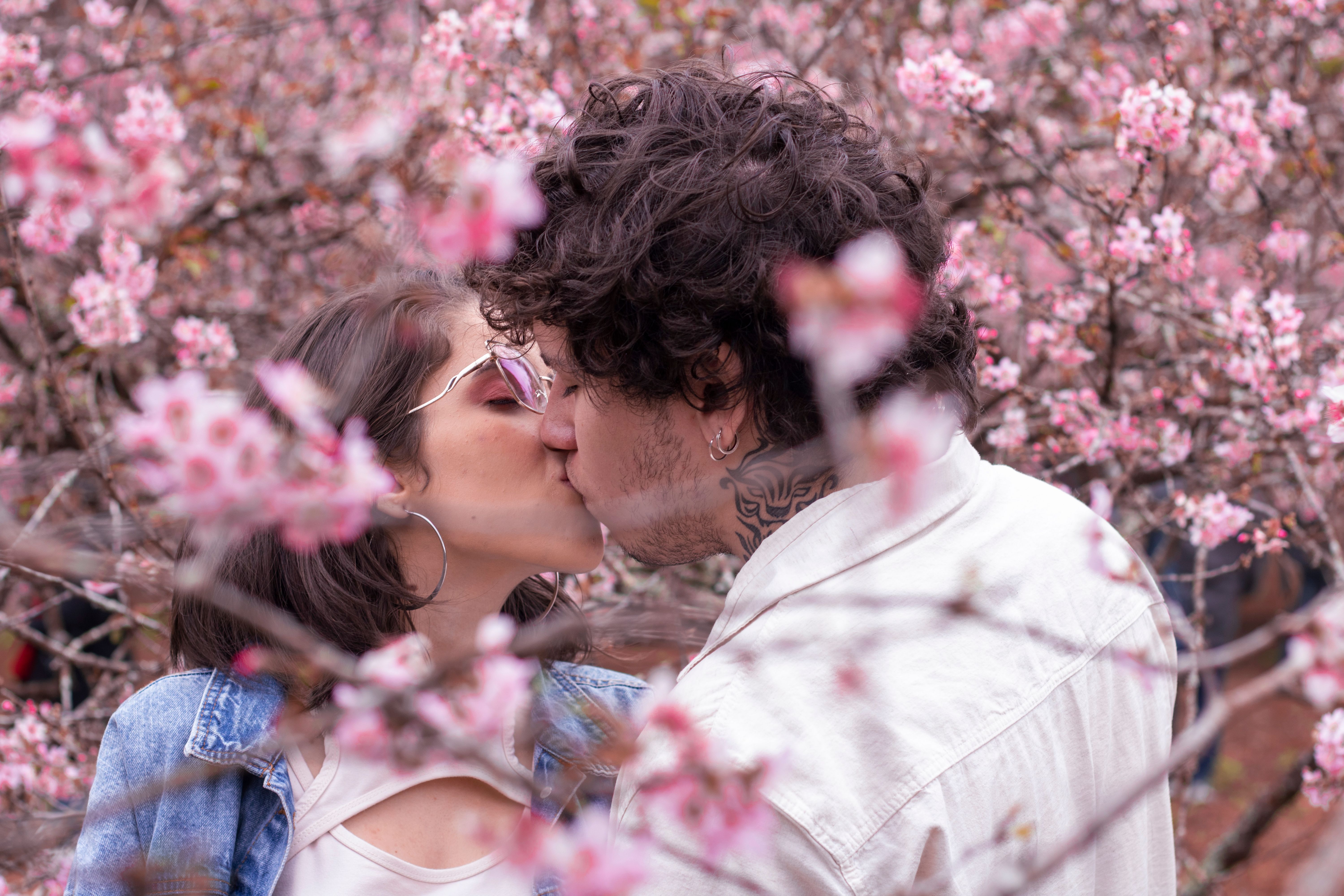 Couple Kissing near Pink Flowers · Free Stock Photo